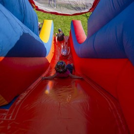 Enfant glissant à l'intérieur d'un toboggan gonflable